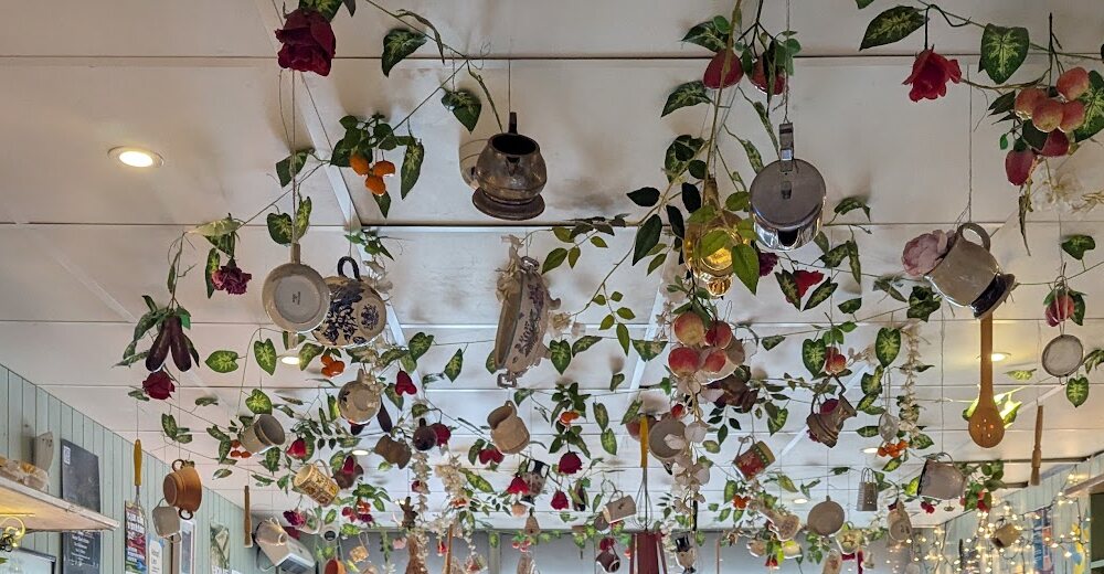 The ceiling at Mooz hung with teapots, pans, cups and paper roses on green vines